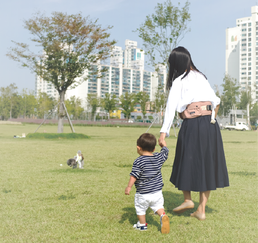 베베핏 라이트를 착용한 엄마와 손잡고 걷는 아기의 사진